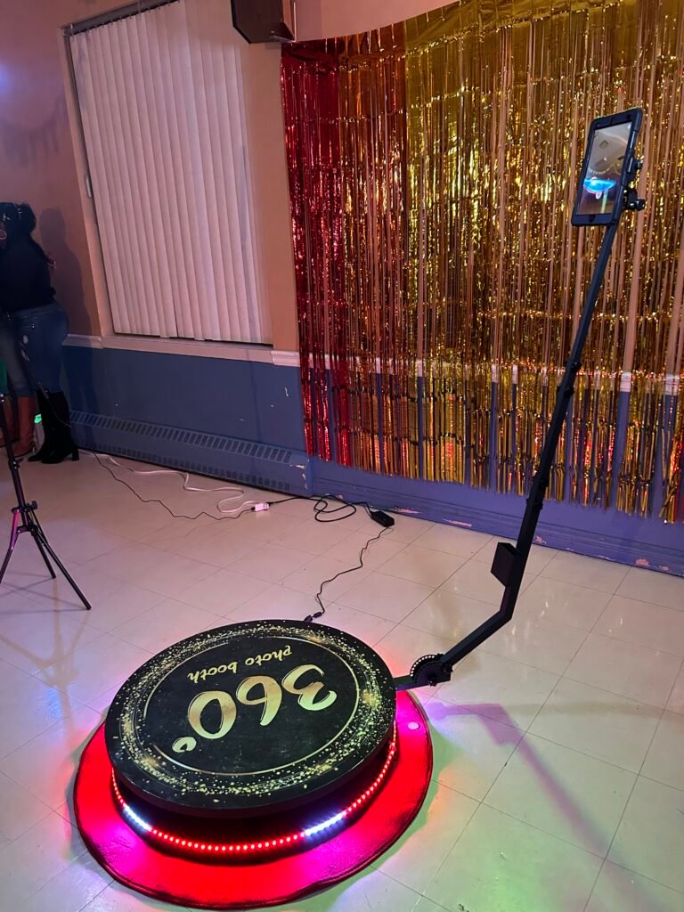Plateforme 360 &Eacute;venox devant un rideau &agrave; paillettes dor&eacute;es, anneau lumineux rouge et vert