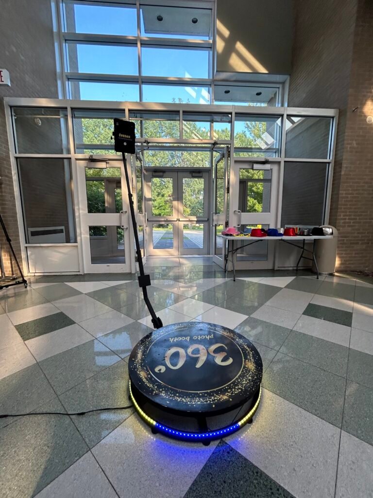 Plateforme 360 &Eacute;venox pos&eacute;e dans un hall vitr&eacute;, anneau lumineux bleu allum&eacute;, bras motoris&eacute; et table d&rsquo;accessoires derri&egrave;re