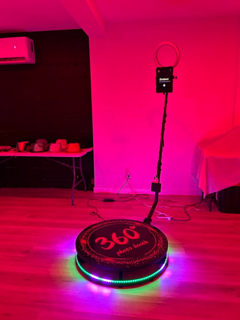 Plateforme 360 &Eacute;venox dans une salle baign&eacute;e de lumi&egrave;re magenta, anneau LED multicolore au sol