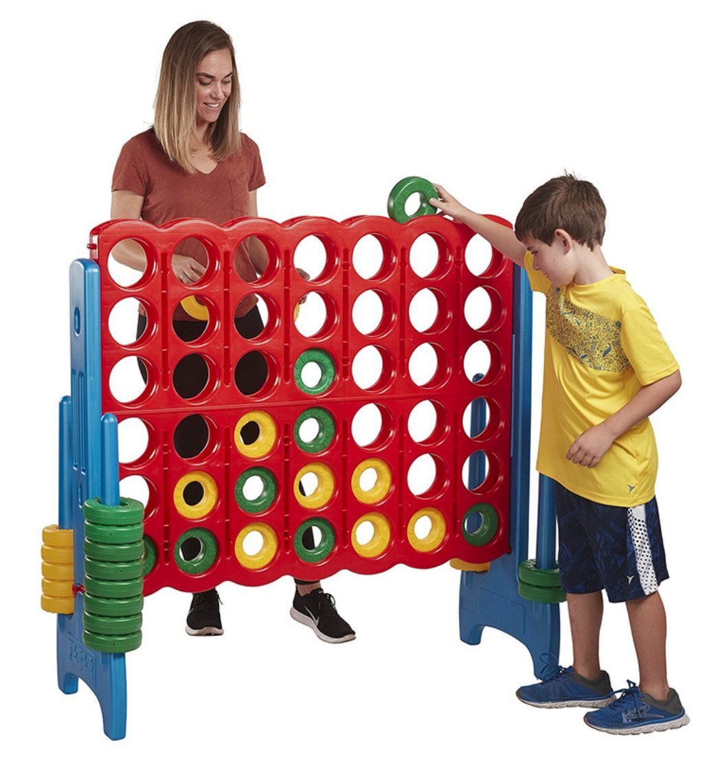 Grille de puissance 4 g&eacute;ante rouge sur pieds bleus, hauteur d'adulte&nbsp;; une femme et un jeune gar&ccedil;on y glissent des jetons verts et jaunes