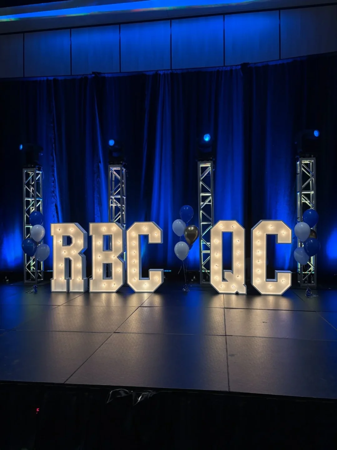 Lettres lumineuses géantes RBC QC installées sur la scène d'un événement corporatif