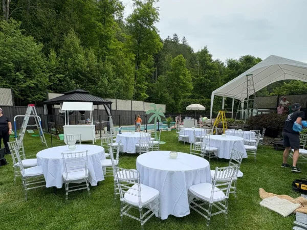 Chapiteau blanc mont&eacute; avec tables rondes en ext&eacute;rieur