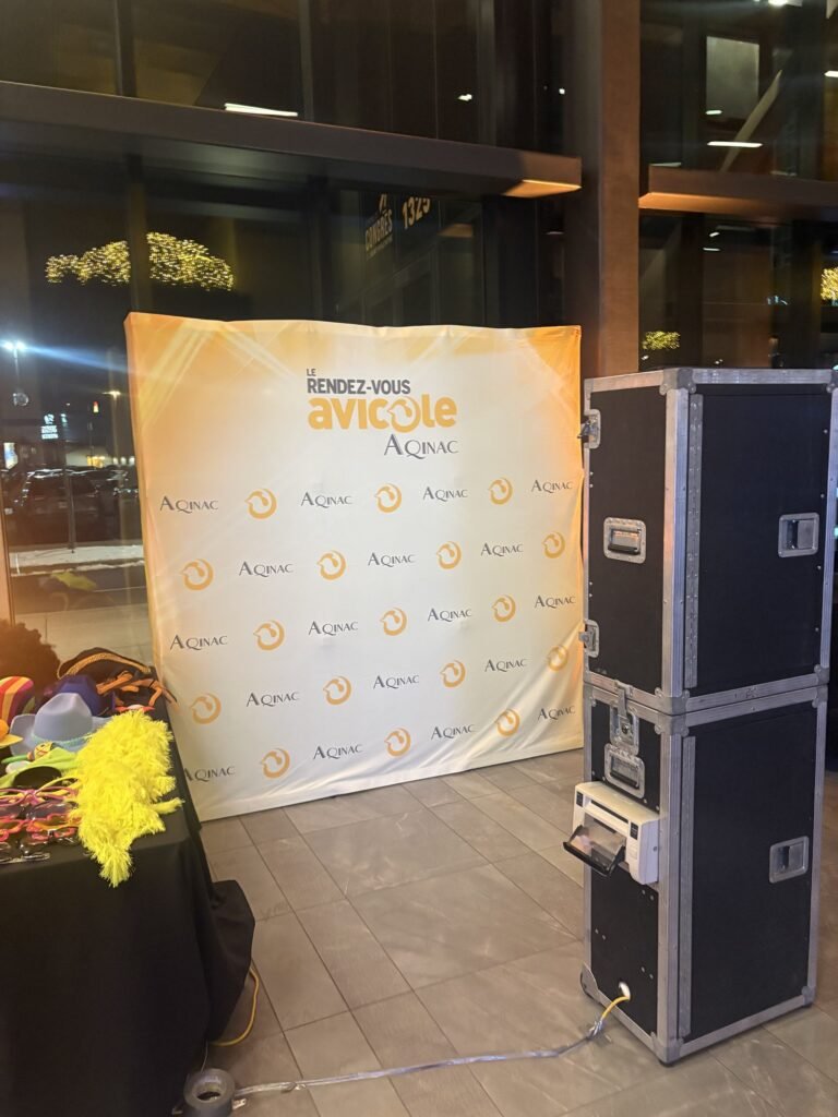 Borne photo &Eacute;venox &agrave; c&ocirc;t&eacute; d&rsquo;un mur commandit&eacute; de congr&egrave;s, avec table d&rsquo;accessoires devant une baie vitr&eacute;e