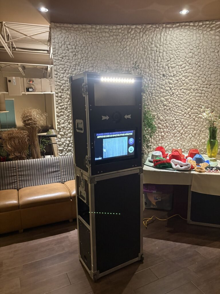 Borne photo &Eacute;venox install&eacute;e dans un salon au mur de pierre blanche, canap&eacute; de cuir et table d&rsquo;accessoires &agrave; c&ocirc;t&eacute;