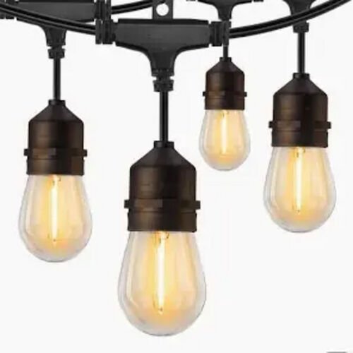 Guirlande de lumiere a cable noir et douilles noires, ampoules a filament allumees, vue rapprochee