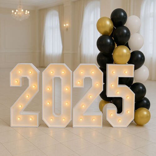 Quatre chiffres lumineux formant 2025 dans une salle claire, une colonne de ballons noirs et dor&eacute;s &agrave; leur droite