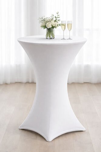 Nappe extensible blanche sur une table à cocktail, avec un bouquet et deux flûtes posés dessus