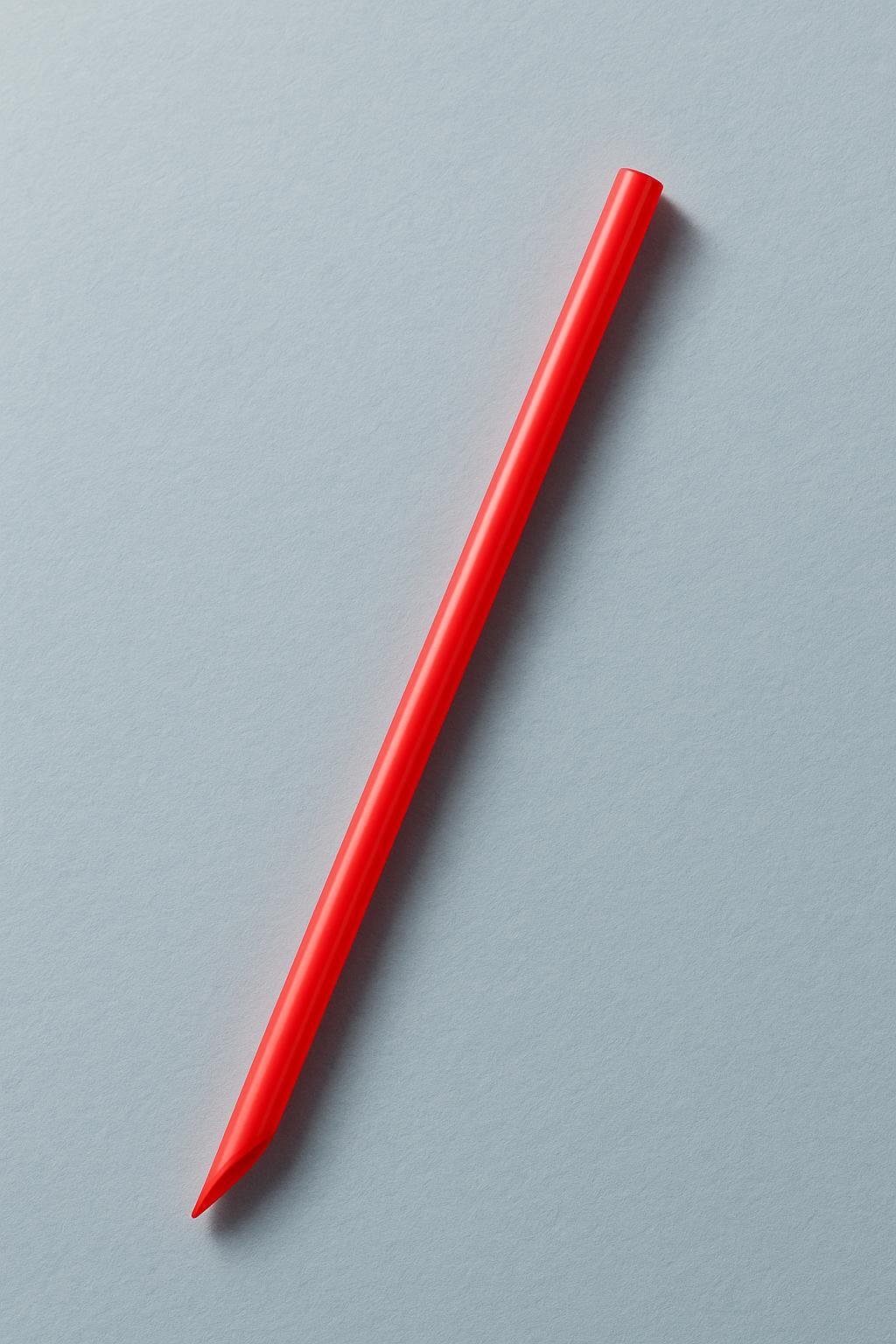 Paille jumbo rouge &agrave; bout biseaut&eacute;, pos&eacute;e en diagonale sur un fond gris