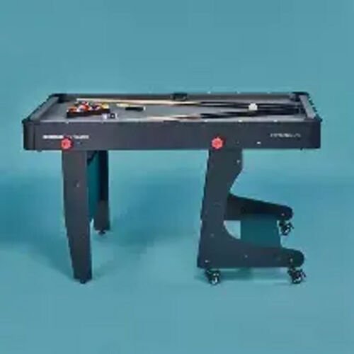 Table de billard portative noire sur roulettes, un piétement déplié et l'autre replié ; billes, triangle et deux queues posés sur le tapis