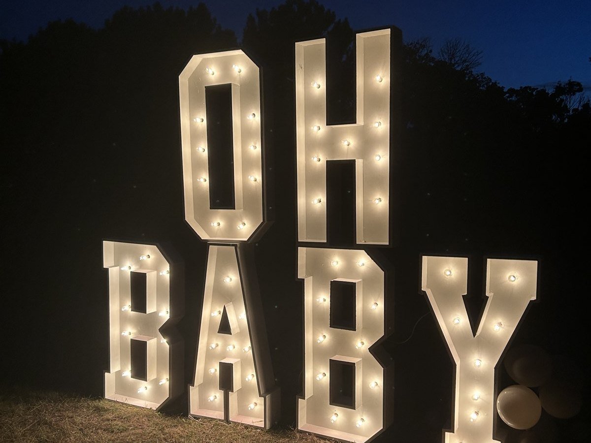 Lettres lumineuses OH BABY d'Évenox de 4 pieds allumées sur le gazon, le soir
